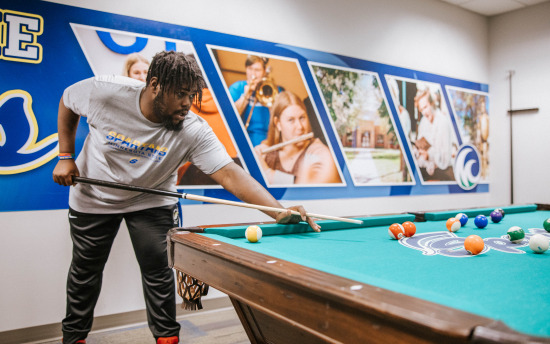 a person is playing pool in front of a wall
