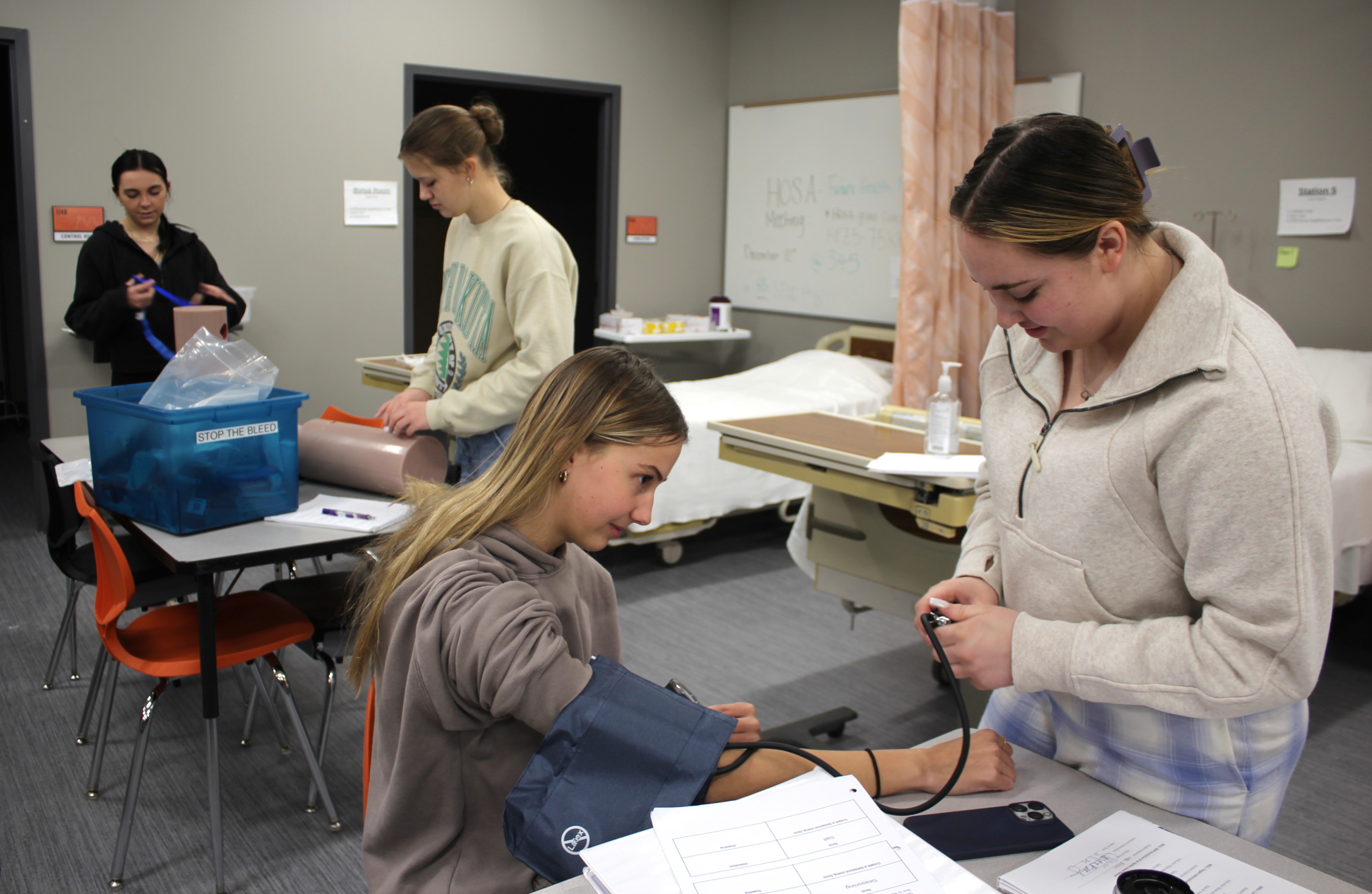 Hope Bloom, right, checks Tori Schmitz’s blood pressure during a Health 2213 class at the Moorhead High School Career Academy in mid-November.