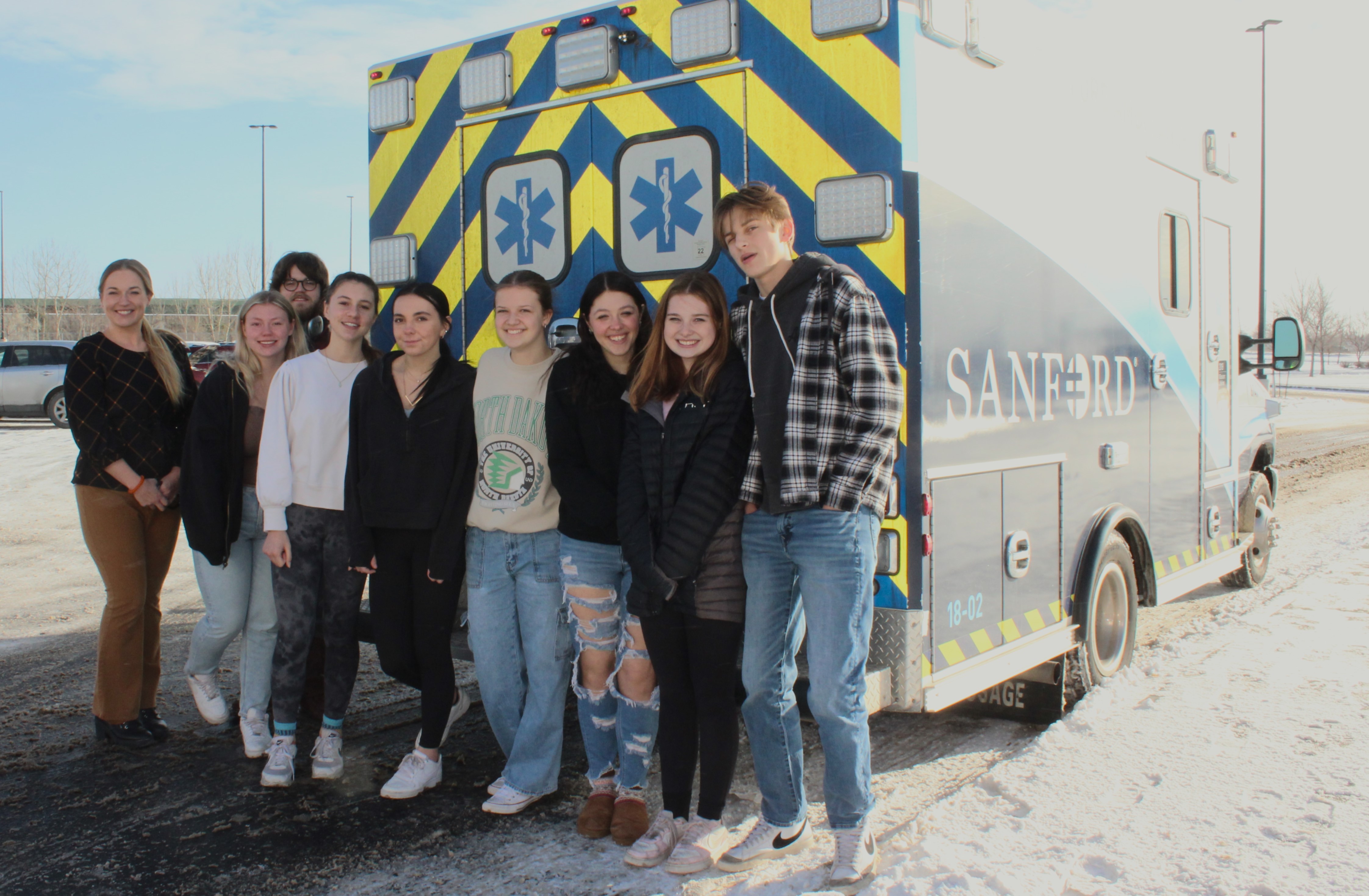 Moorhead High School students from the Health 2213 emergency medical responder course pose with their instructor, Trista Berg, pictured far left, in front of one of the Sanford Ambulances that frequently visit the Moorhead High School Career Academy as a part of the hands-on class. 