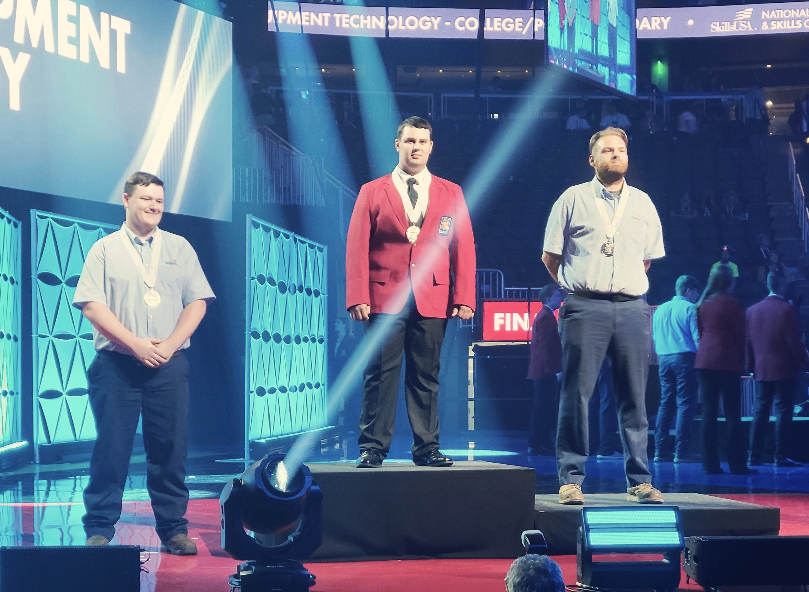 Cole Riegert, at left, stands on the winners' stage with his bronze medal at the 2024 SkillsUSA Championships in Atlanta. 