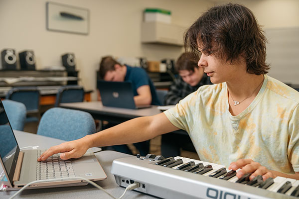 A music student works at a keyboard