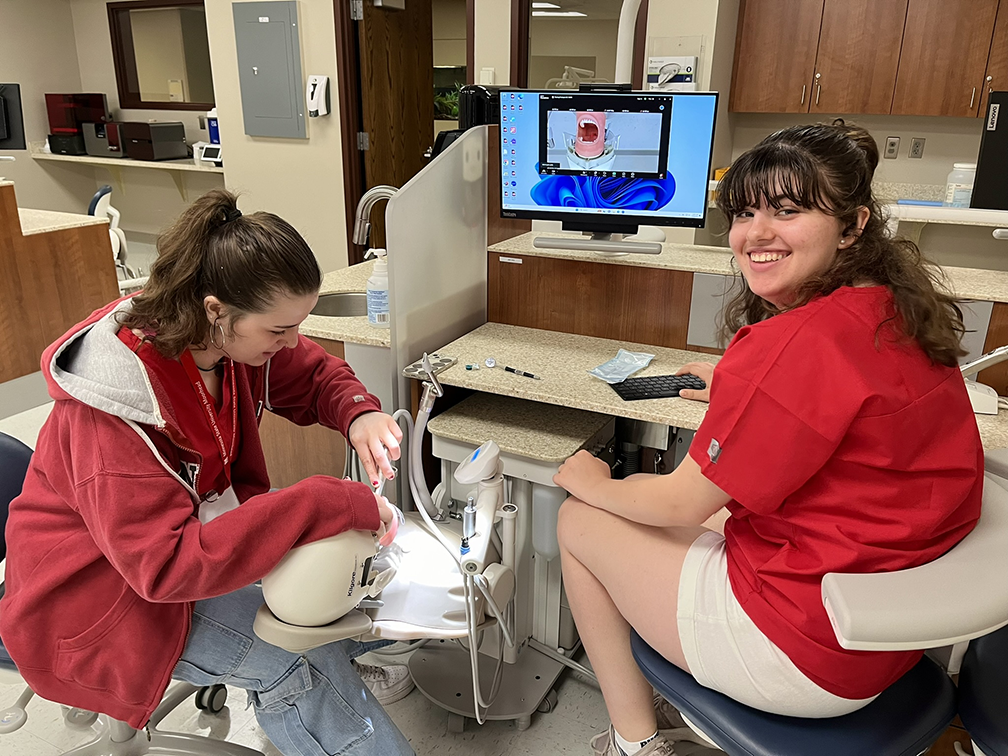 Two Scrubs Camp students practice dental work