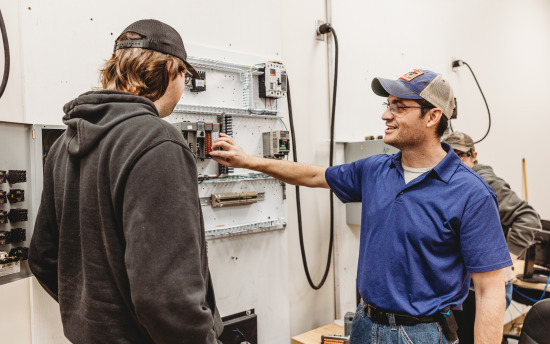 An electrical student looking at a breaker box