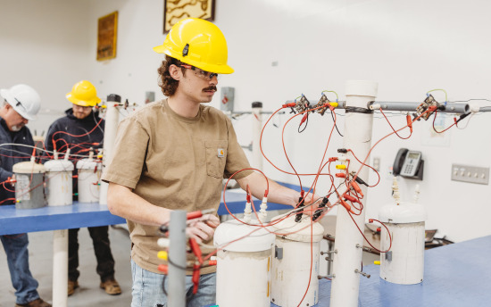 An electrical line worker student conducting a lab test