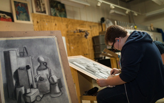 A student draws at an easel