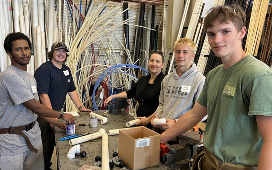 Students work with pipes at Herdina Construction Camp