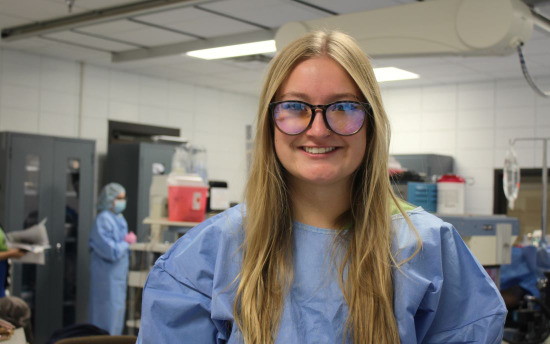 Breena Wheeler, Surgical Technology student, in a blue hospital gown