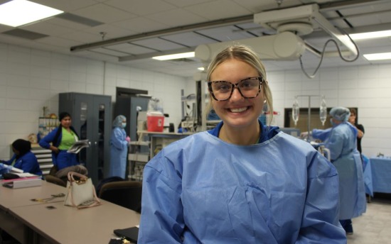 Ryleigh Brendmoen, Surgical Technology student, in a blue hospital gown