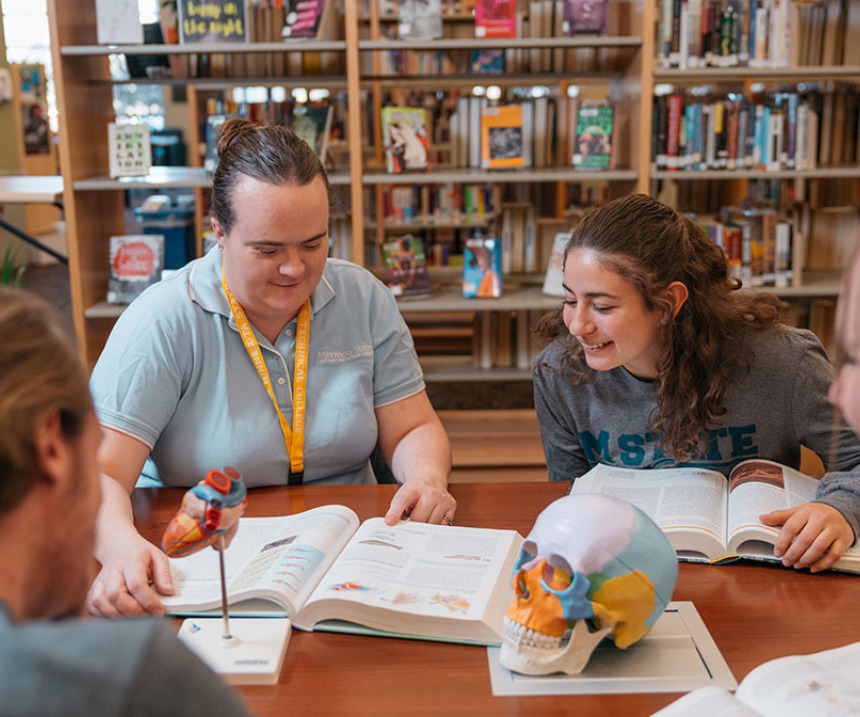  A group of students studies at a table in the library