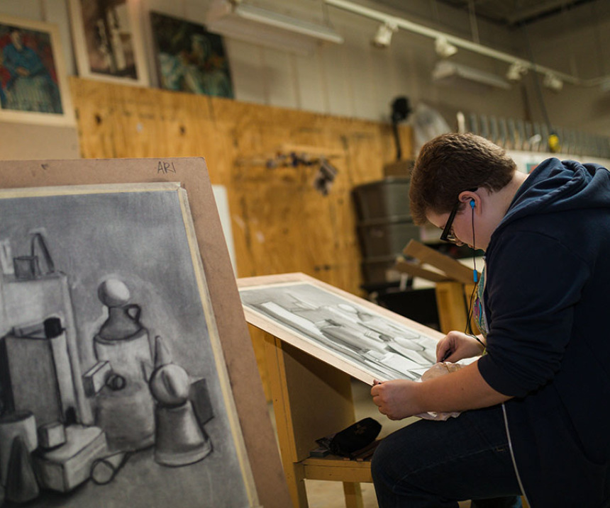 A student draws at an easel