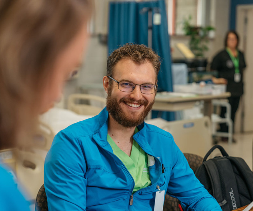 An M State student in scrubs smiles at the camera