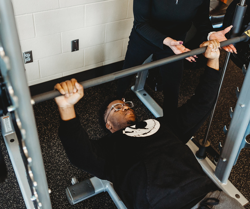 An M State student lifts weights