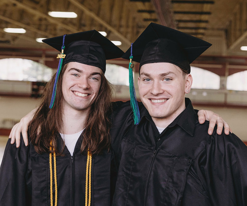 Two graduates smile for the camera